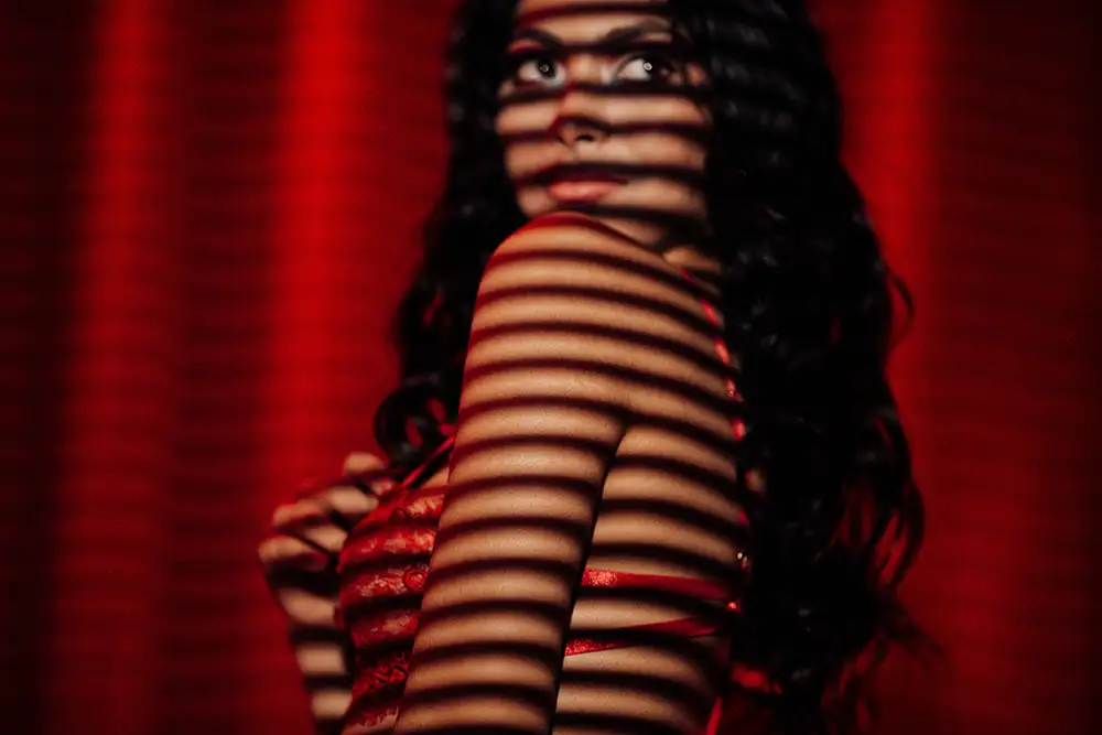 Woman in red dress with striped shadow pattern